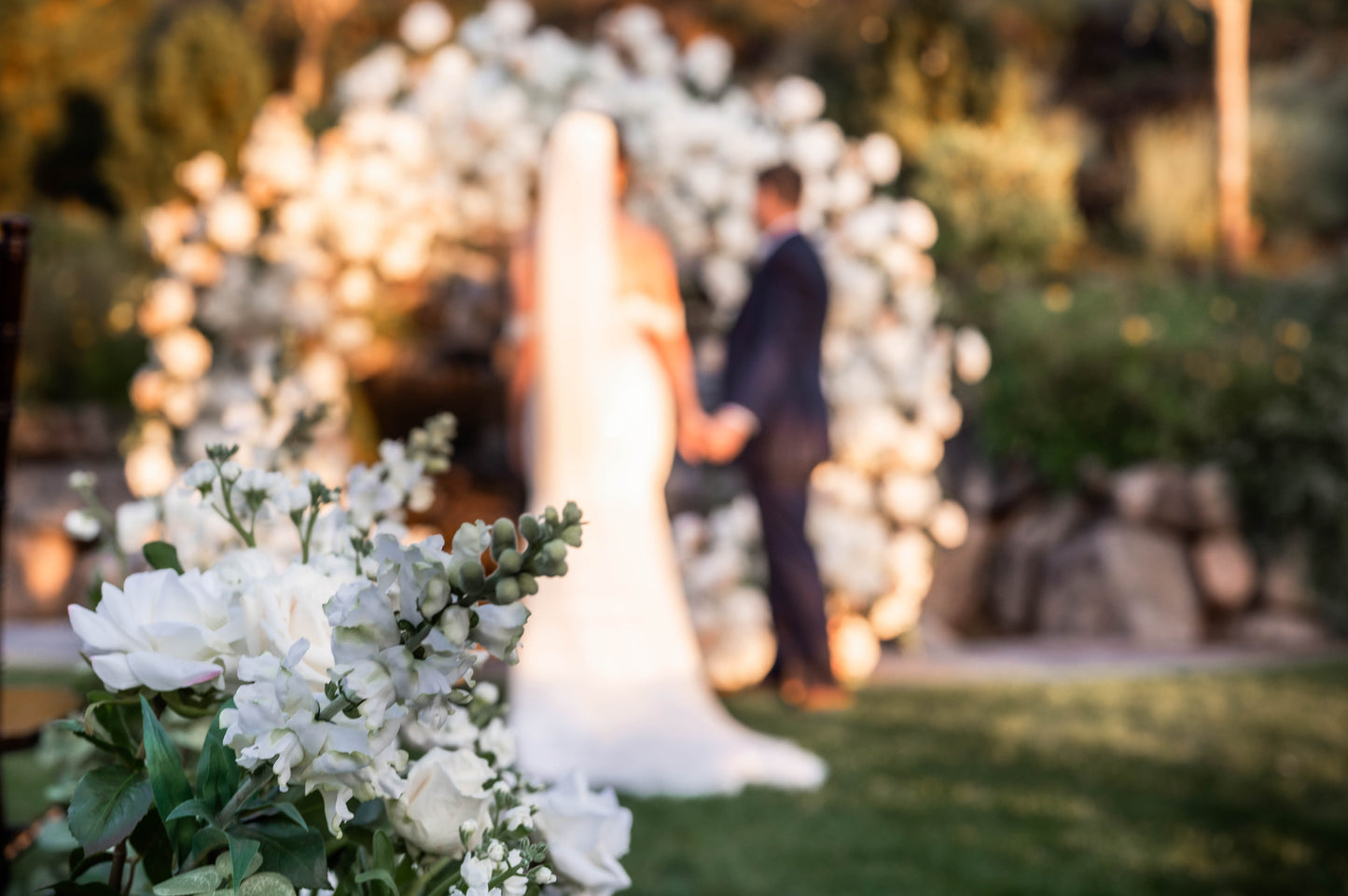 White floral wedding circle arch covered in peonies hydrangeas roses and clematis