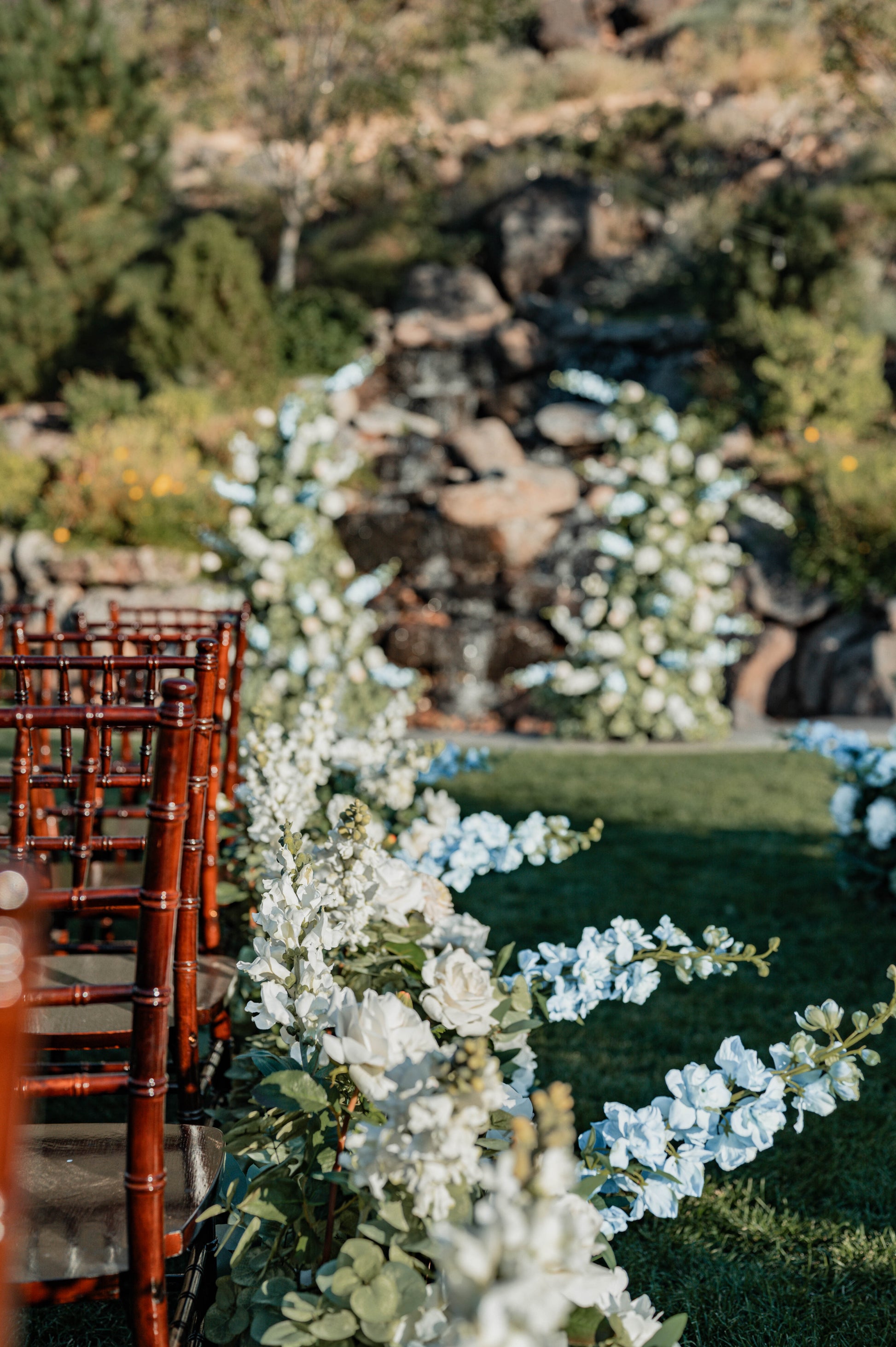 Wedding aisle flowers that match flower pillars in a touch of blue